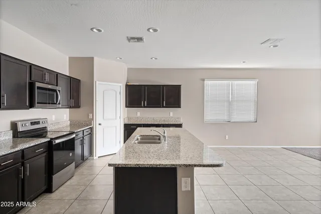 a kitchen with stainless steel appliances granite countertop a sink and a stove