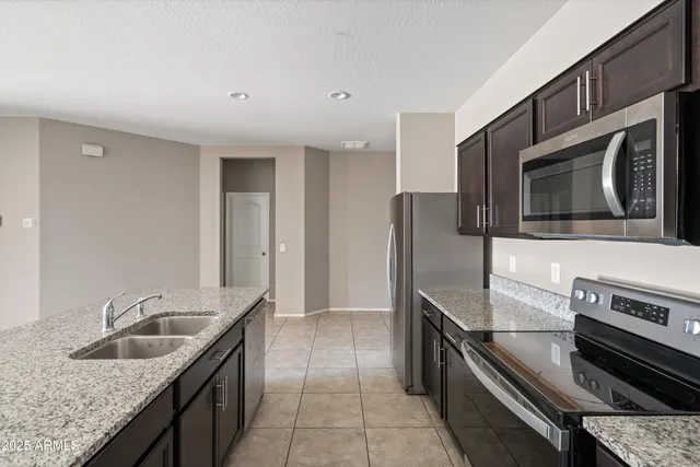 a kitchen with stainless steel appliances granite countertop a sink and a stove