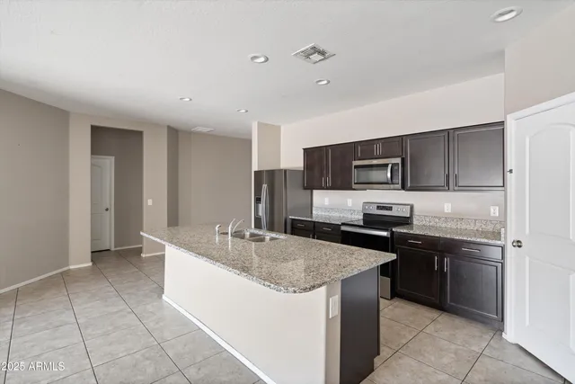a kitchen with stainless steel appliances granite countertop a sink and a stove