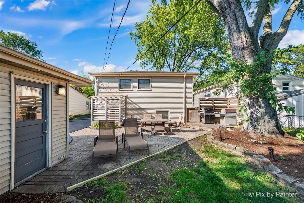 571 Lowden Avenue Glen Ellyn, IL 60137 - Photo 7 of 30 a view of a patio with table and chairs potted plants and a large tree