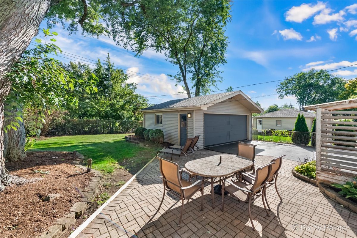 571 Lowden Avenue Glen Ellyn, IL 60137 - Photo 8 of 30 a view of a backyard with table and chairs with wooden fence and plants