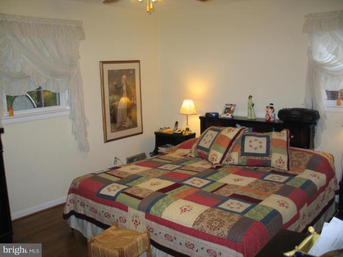 1007 Loxford Terrace Silver Spring, MD 20901 - Photo 7 of 15 a bedroom with a bed and wooden floor