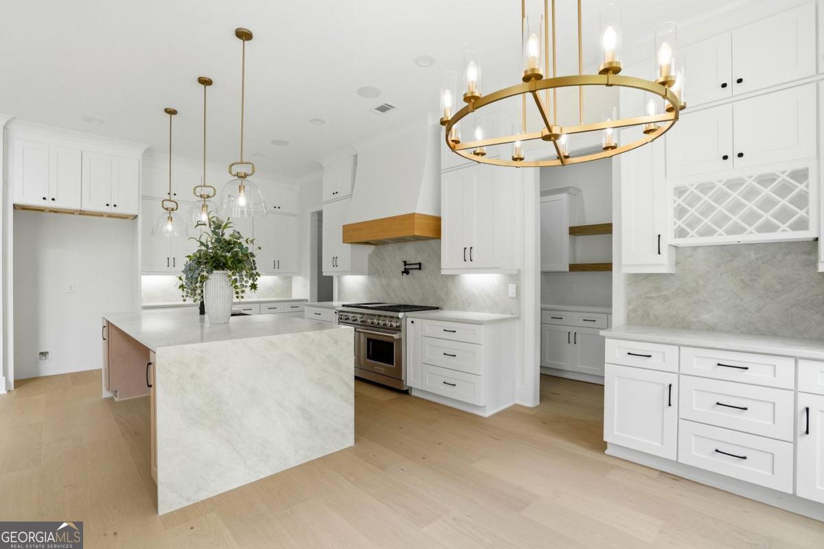 1557 Whitley Road Dacula, GA 30019 - Photo 12 of 46 a kitchen with stainless steel appliances a stove a chimney a sink and cabinets