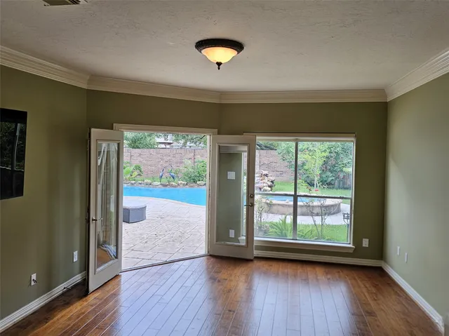 a view of a big room with wooden floor and windows