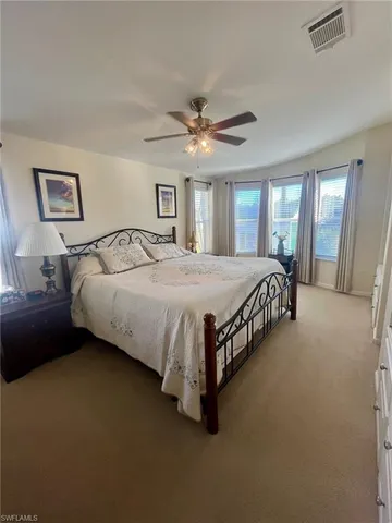 a bedroom with a bed chandelier and a window