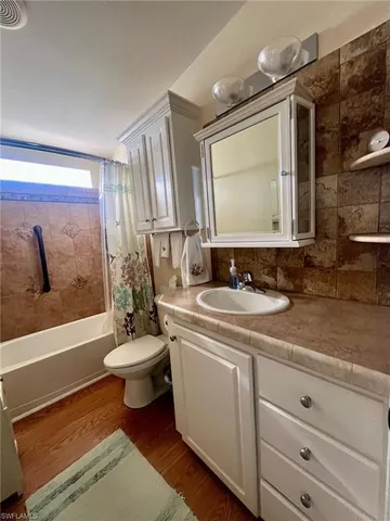 a bathroom with a double vanity sink toilet mirror and bathtub