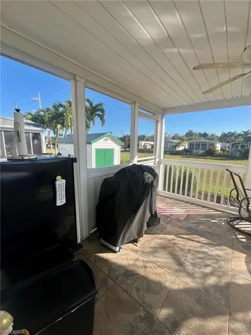 a living room with a bed furniture large window and kitchen view