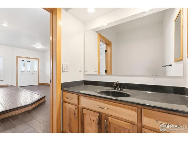 a bathroom with a granite countertop sink and a mirror