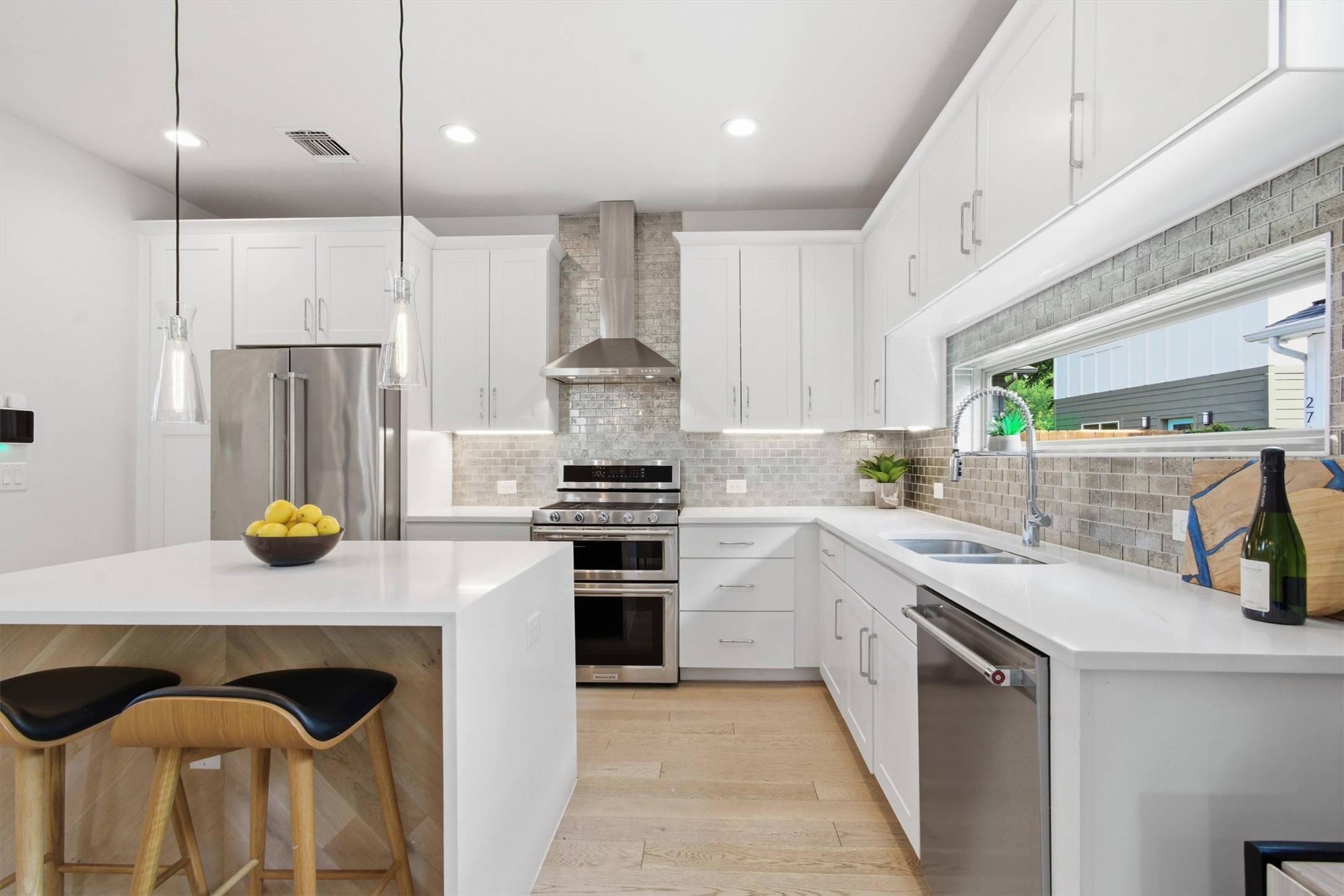 2710 Zaragosa Street, Unit A Austin, TX 78702 - Photo 10 of 29 Designer kitchen featuring a statement range hood, quartz counters, island breakfast bar, and crisp shaker cabinetry.
