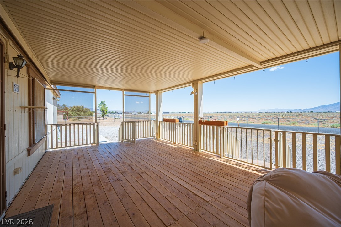 3200 Maple Road Pahrump, NV 89048 - Photo 8 of 53 Overlooking the vast desert, this property features a generously sized, covered porch with natural wood flooring.