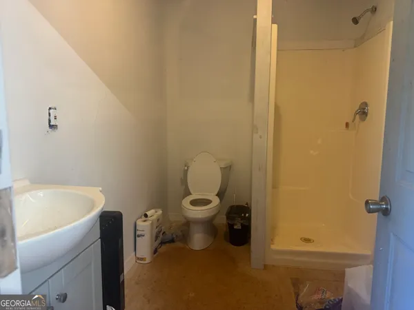 a bathroom with a granite countertop toilet and a sink