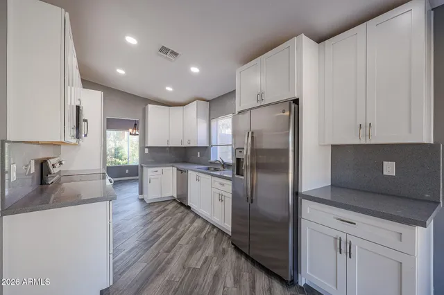 a kitchen with stainless steel appliances a refrigerator sink and cabinets