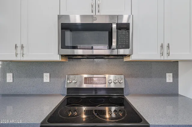 a large kitchen with cabinets wooden floor and stainless steel appliances
