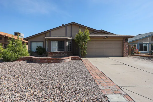 a front view of a house with a yard and potted plants