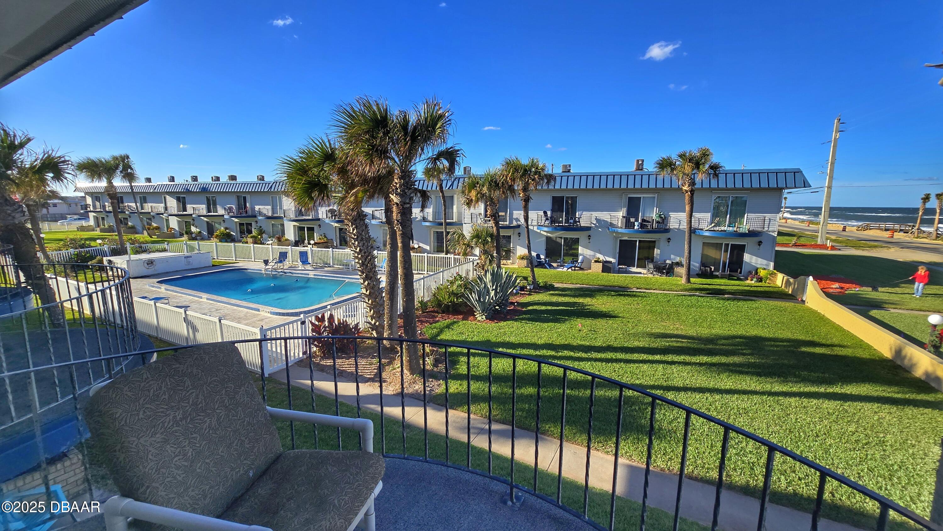 2750 Ocean Shore Boulevard, Unit 8 Ormond Beach, FL 32176 - Photo 15 of 60 a view of a chairs and table in patio with a swimming pool