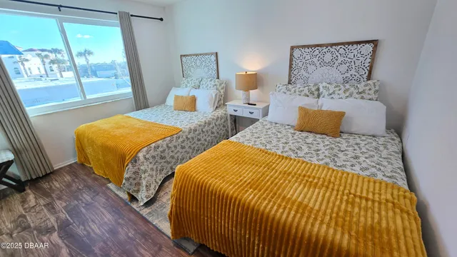 a bedroom with two beds and painting on the wall