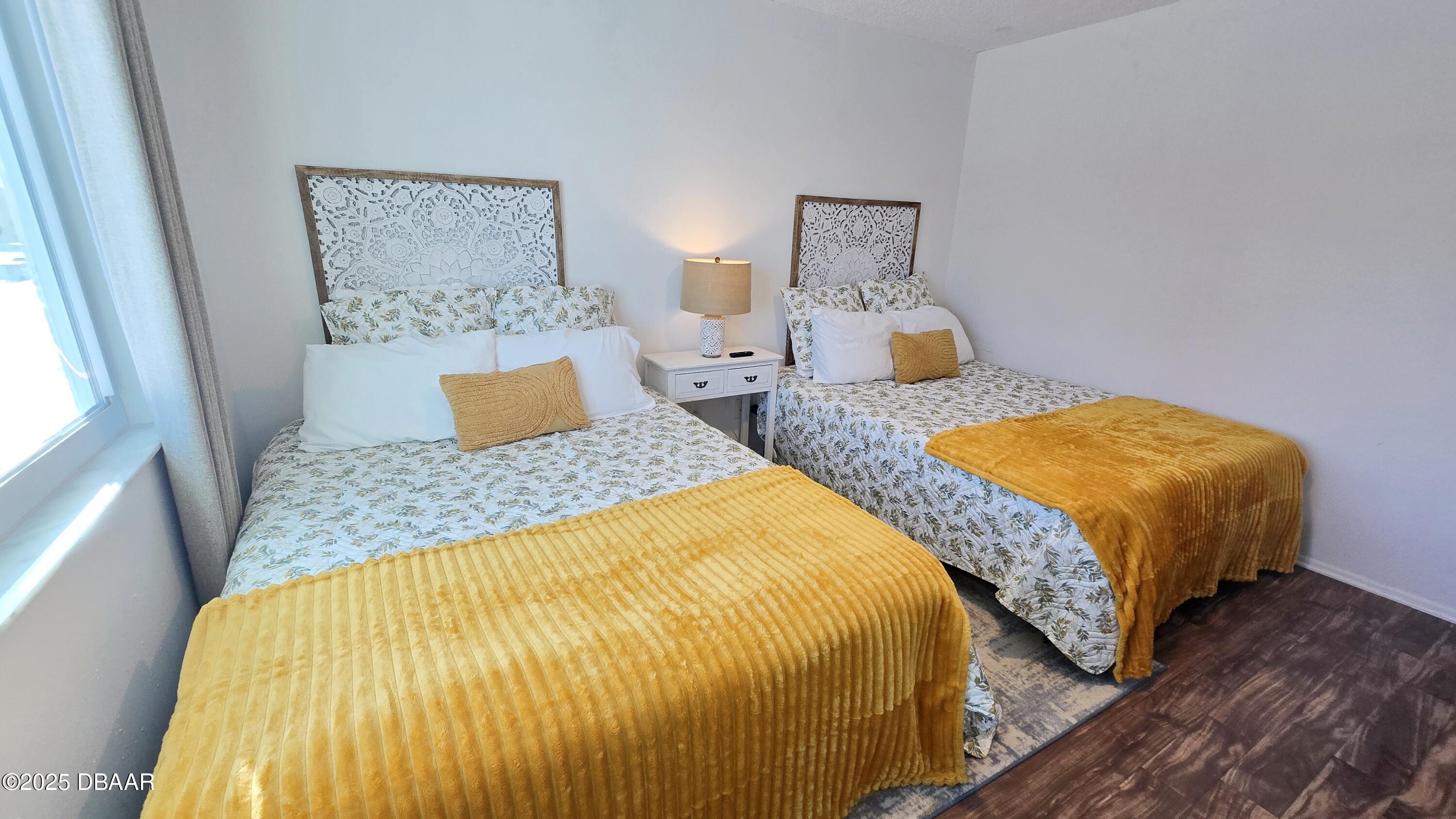 2750 Ocean Shore Boulevard, Unit 8 Ormond Beach, FL 32176 - Photo 17 of 60 a bedroom with two beds and painting on the wall