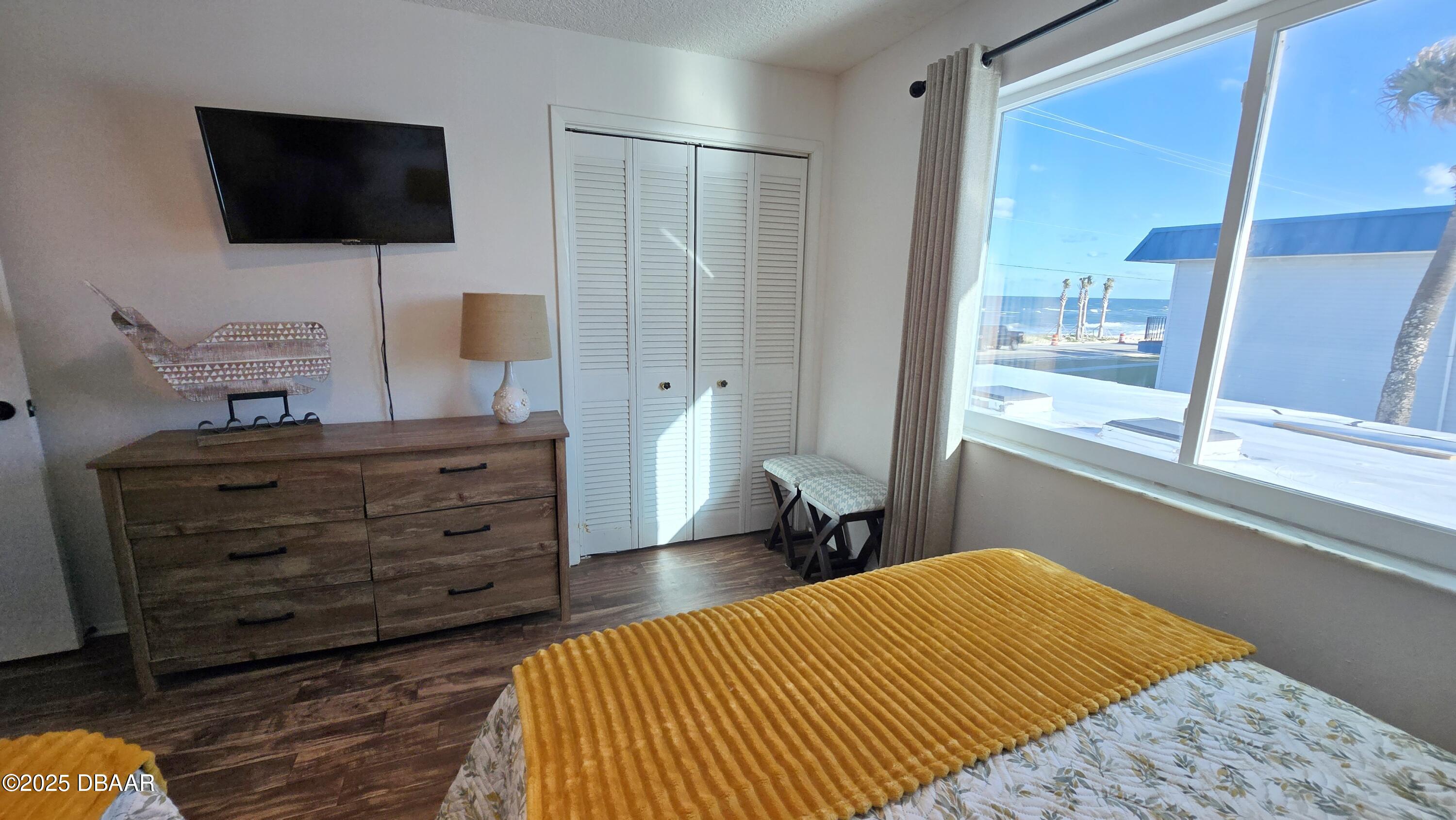 2750 Ocean Shore Boulevard, Unit 8 Ormond Beach, FL 32176 - Photo 18 of 60 a room with a bed and a flat screen tv