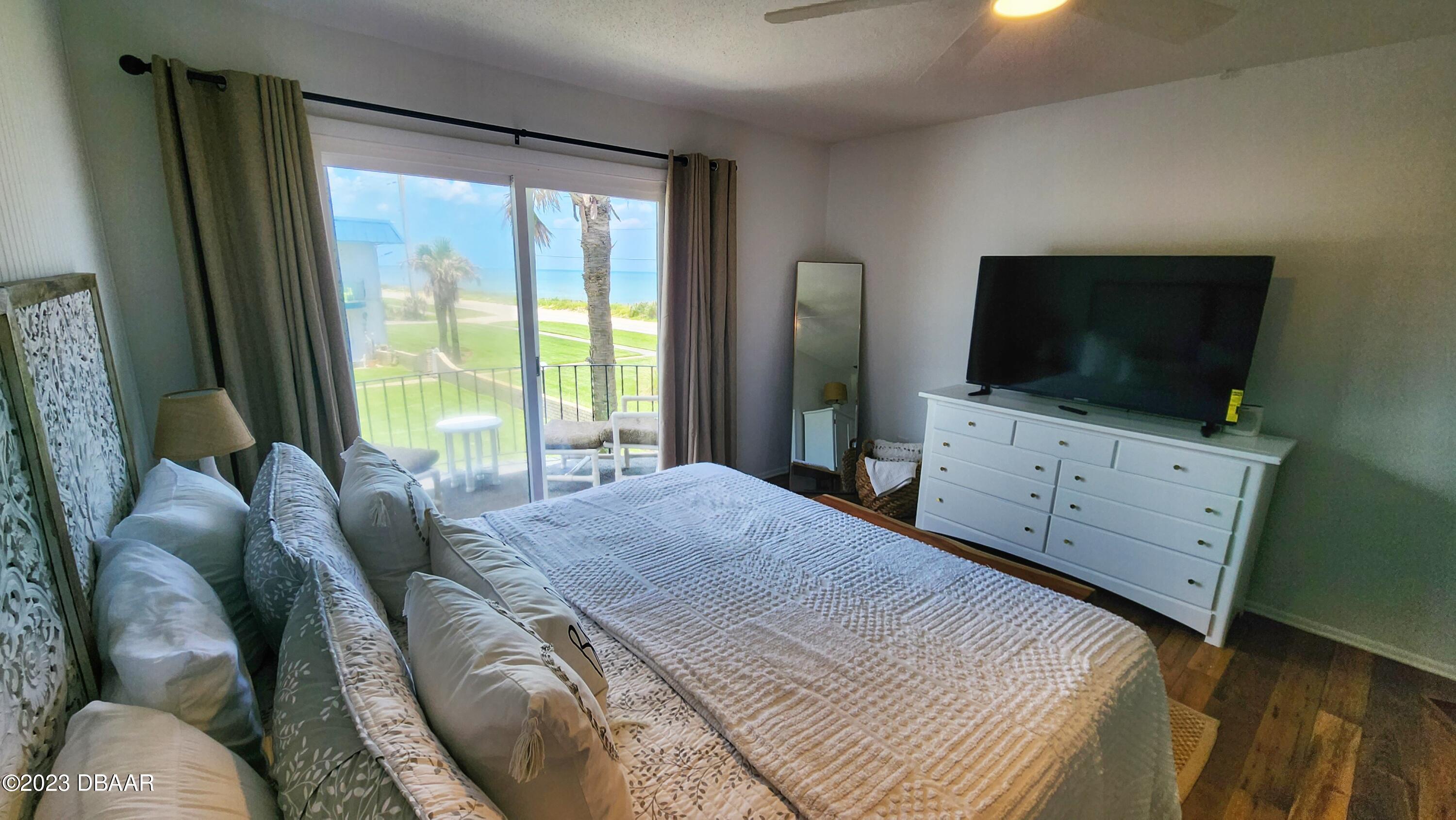 2750 Ocean Shore Boulevard, Unit 8 Ormond Beach, FL 32176 - Photo 23 of 60 a bedroom with a bed and a flat screen tv