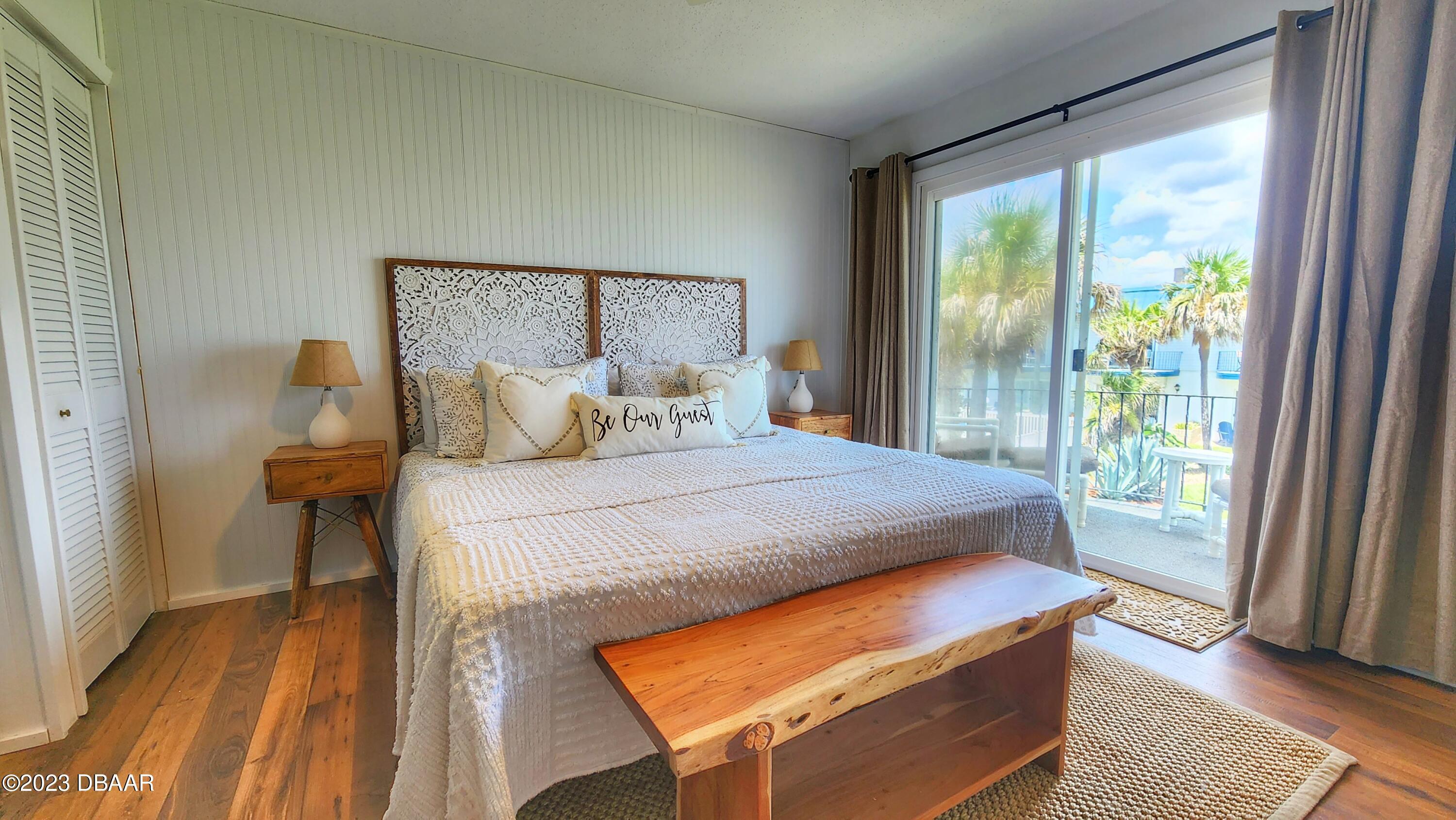 2750 Ocean Shore Boulevard, Unit 8 Ormond Beach, FL 32176 - Photo 24 of 60 a bedroom with a bed and wooden floor