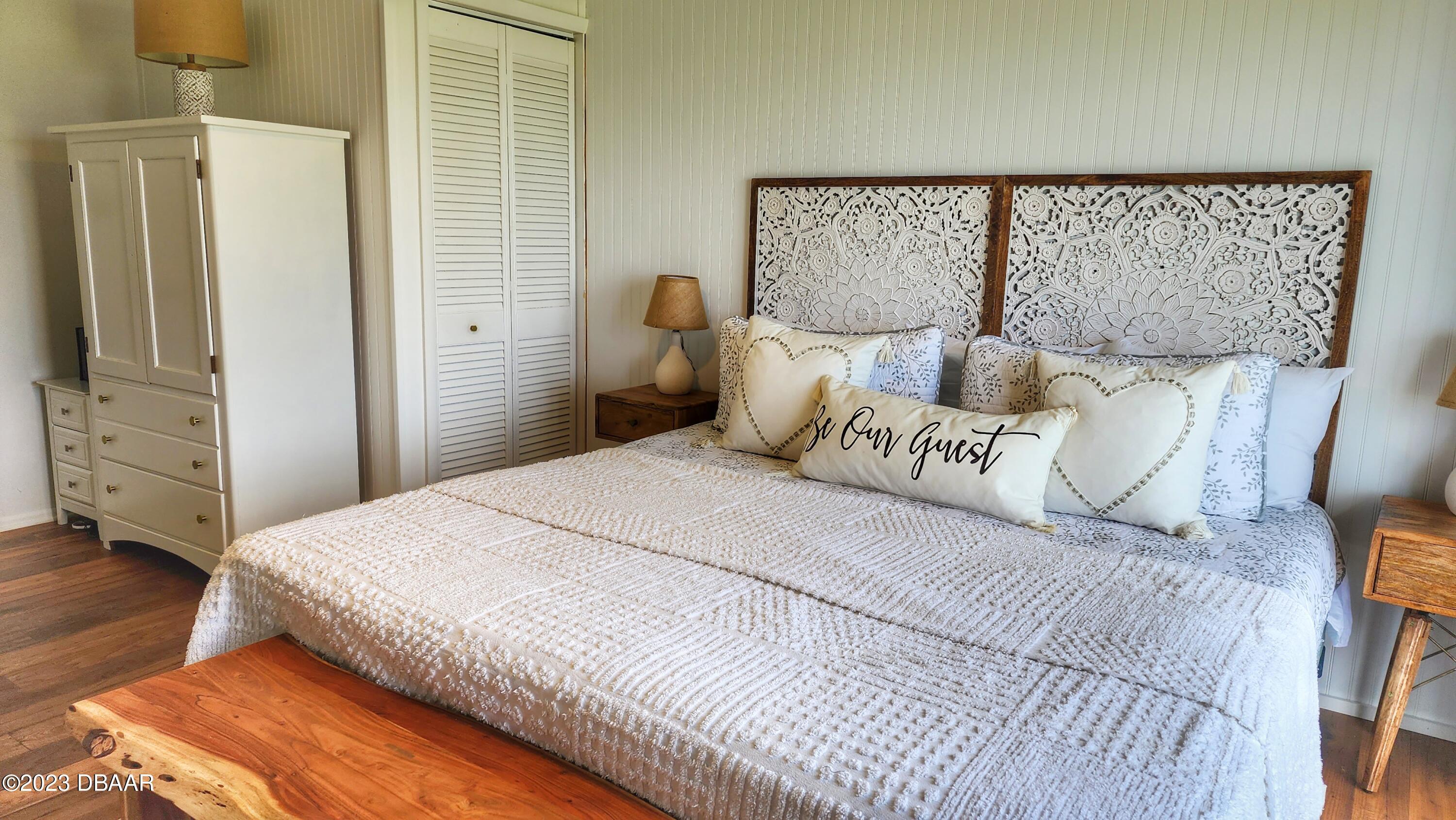 2750 Ocean Shore Boulevard, Unit 8 Ormond Beach, FL 32176 - Photo 31 of 60 a bedroom with a bed and wooden floor