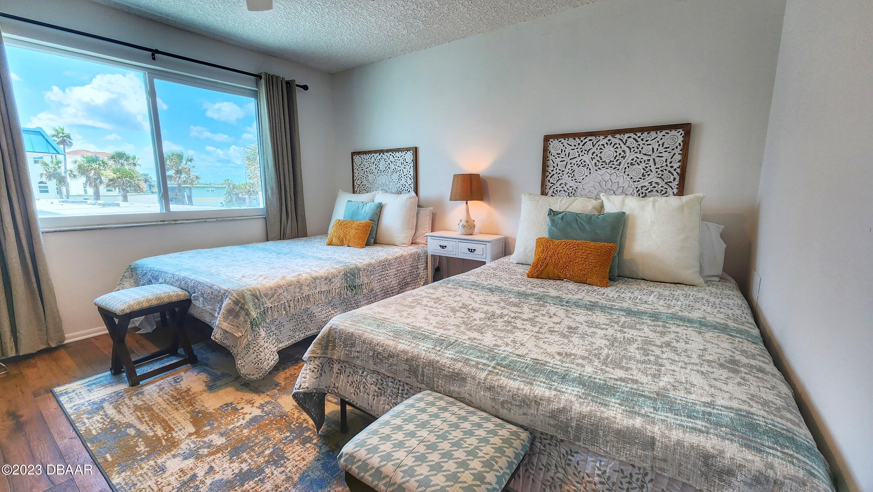 2750 Ocean Shore Boulevard, Unit 8 Ormond Beach, FL 32176 - Photo 32 of 60 a bedroom with two beds and a large window