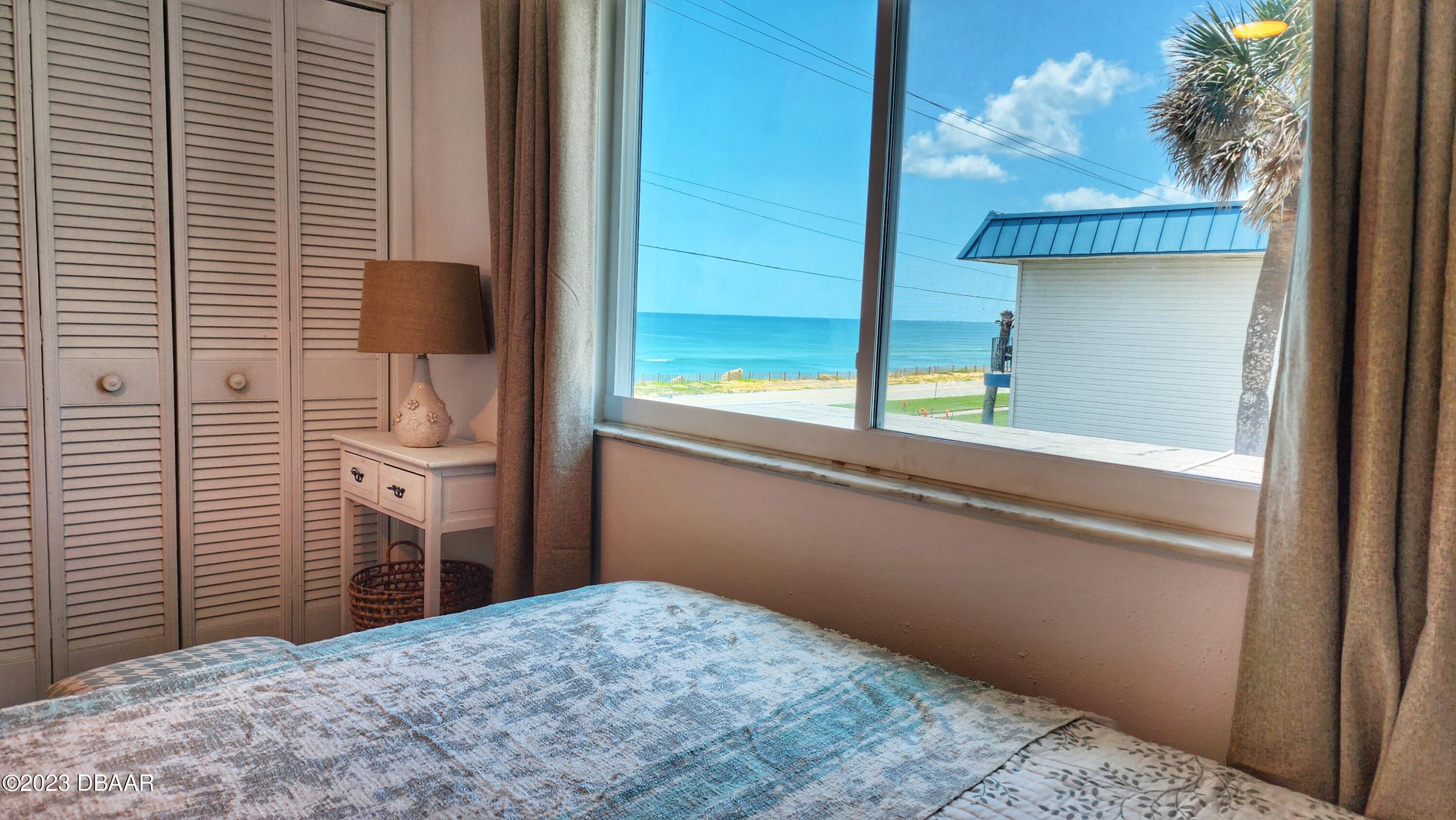 2750 Ocean Shore Boulevard, Unit 8 Ormond Beach, FL 32176 - Photo 34 of 60 a bedroom with a bed and a window