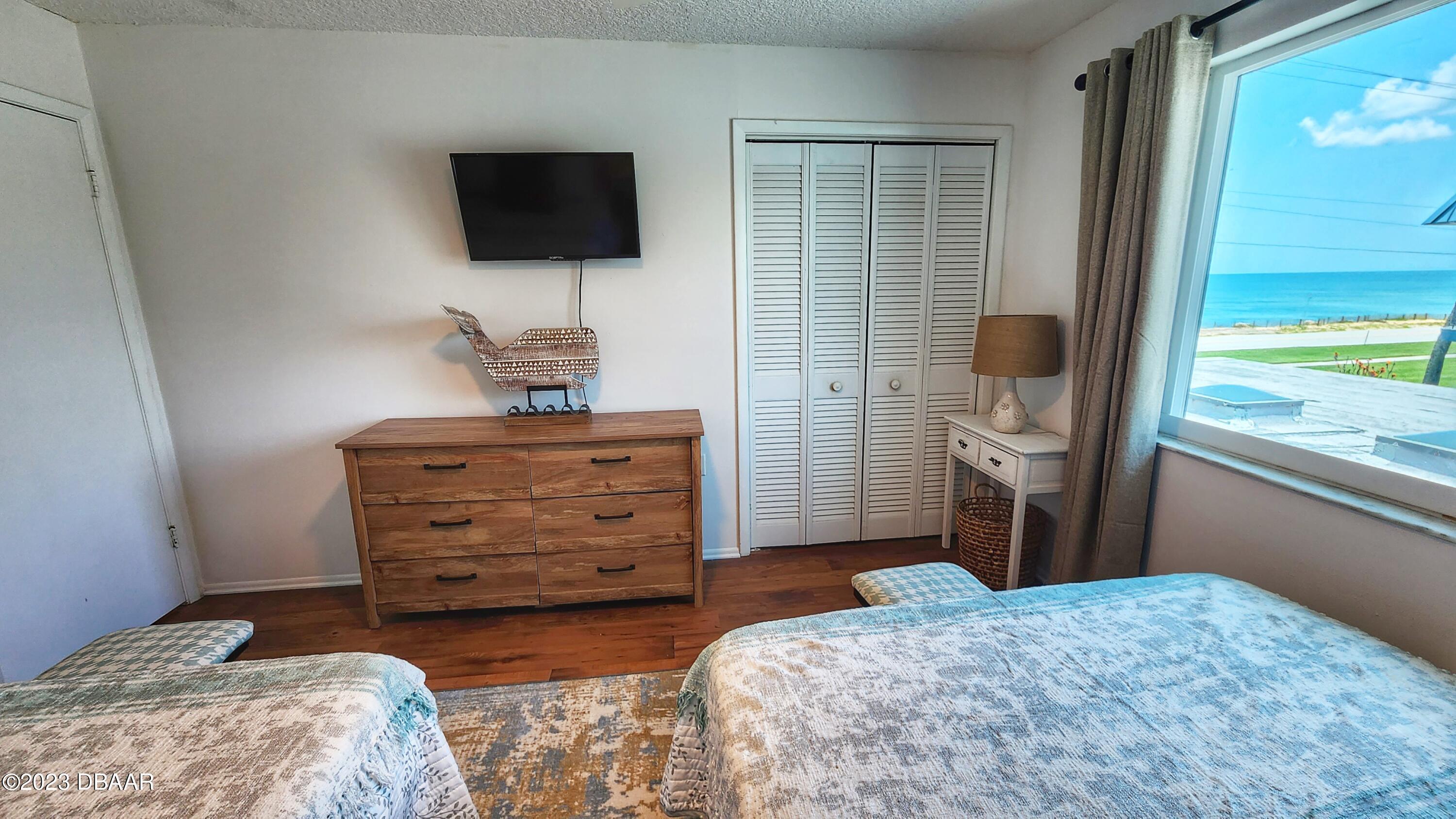 2750 Ocean Shore Boulevard, Unit 8 Ormond Beach, FL 32176 - Photo 35 of 60 a bedroom with a bed and a flat screen tv