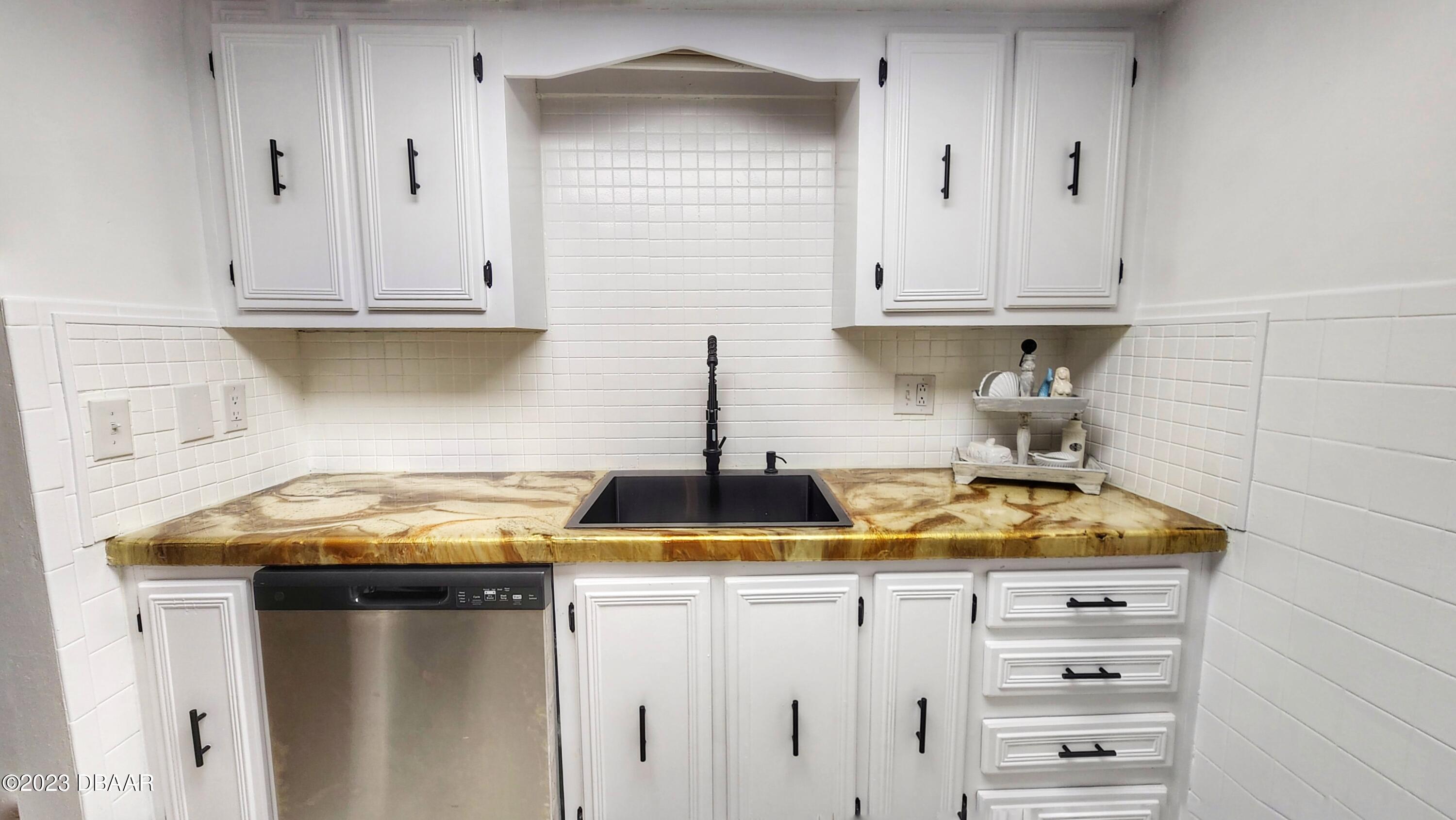 2750 Ocean Shore Boulevard, Unit 8 Ormond Beach, FL 32176 - Photo 45 of 60 a kitchen with white cabinets and a stove