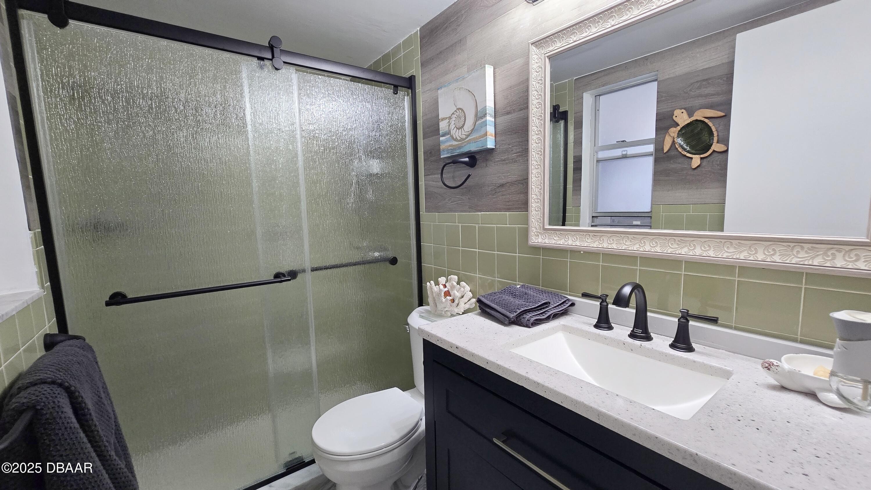 2750 Ocean Shore Boulevard, Unit 8 Ormond Beach, FL 32176 - Photo 55 of 60 a bathroom with a sink a toilet a shower and a mirror