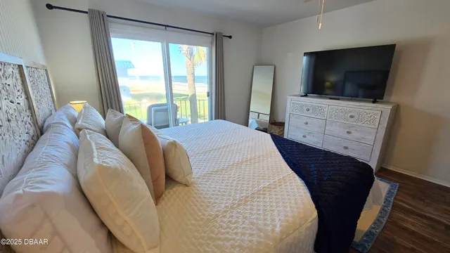 a large bed sitting in a bedroom next to a window