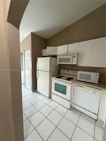 a kitchen with cabinets and white appliances