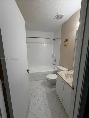 a bathroom with a granite countertop sink a toilet and shower