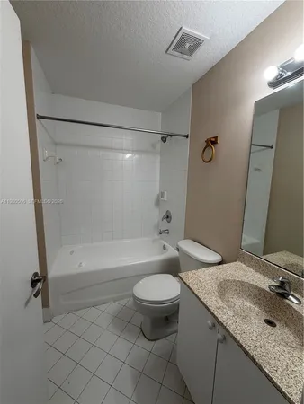 a bathroom with a granite countertop sink a toilet and shower