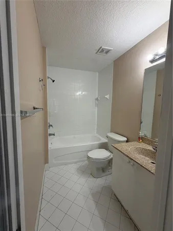 a bathroom with a granite countertop sink a toilet and shower