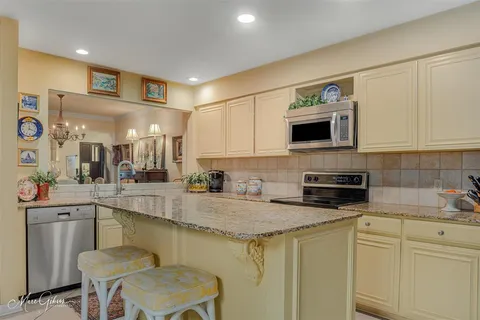 a kitchen with stainless steel appliances granite countertop a sink a stove a microwave a counter top space and cabinets