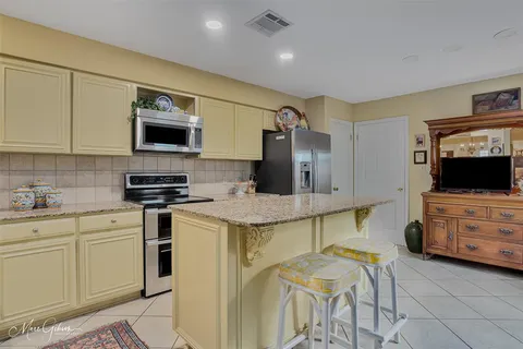 a kitchen with stainless steel appliances granite countertop a stove a sink and a microwave