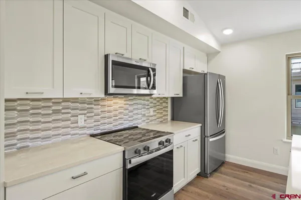 a view of a kitchen with wooden floor and a kitchen