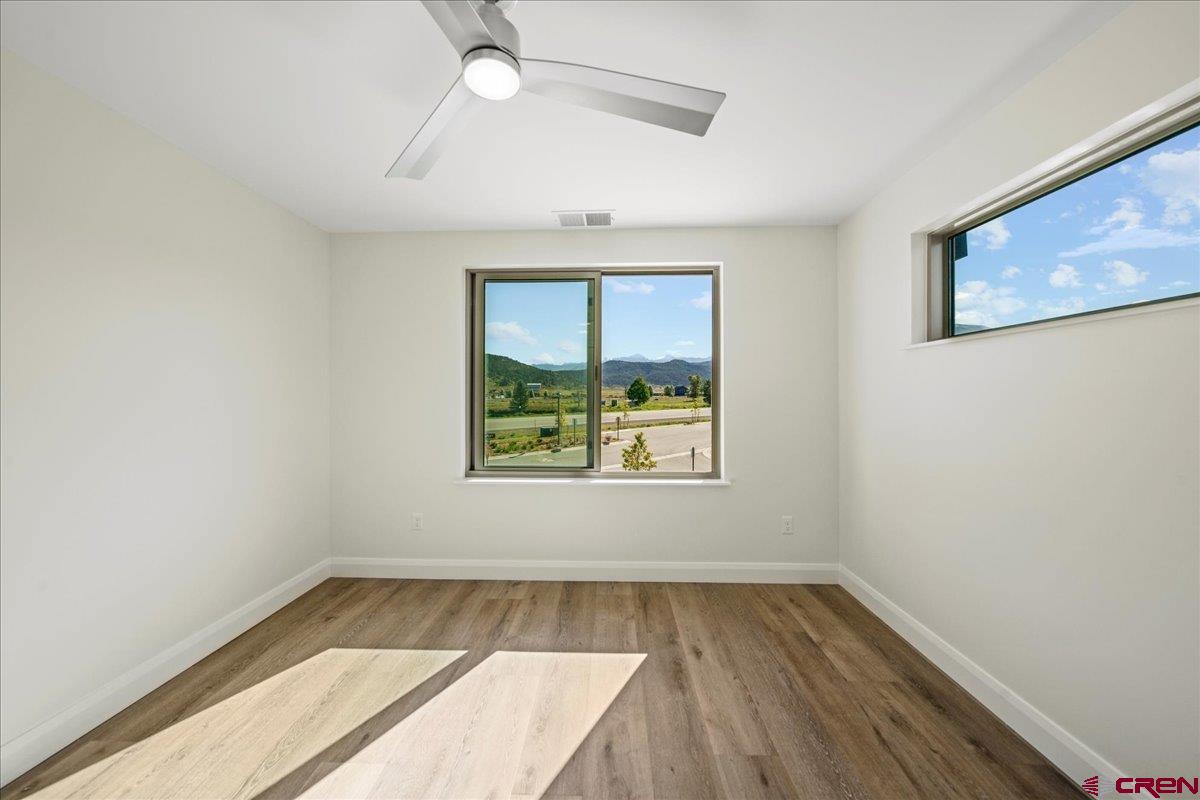 199 Riverfront Lane, Unit 200 Ridgway, CO 81432 - Photo 24 of 28 an empty room with wooden floor and windows