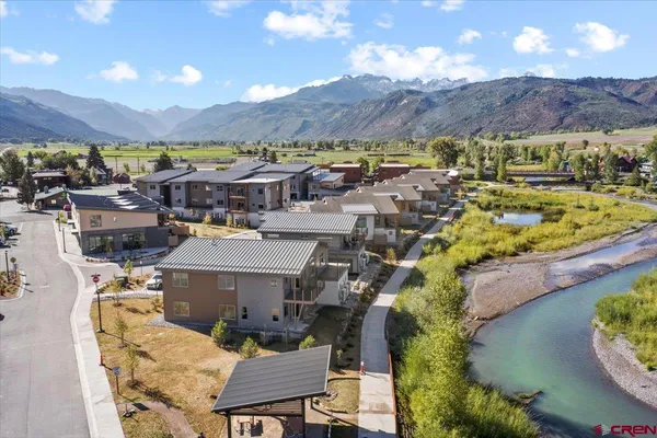 an aerial view of a house with a garden and lake view