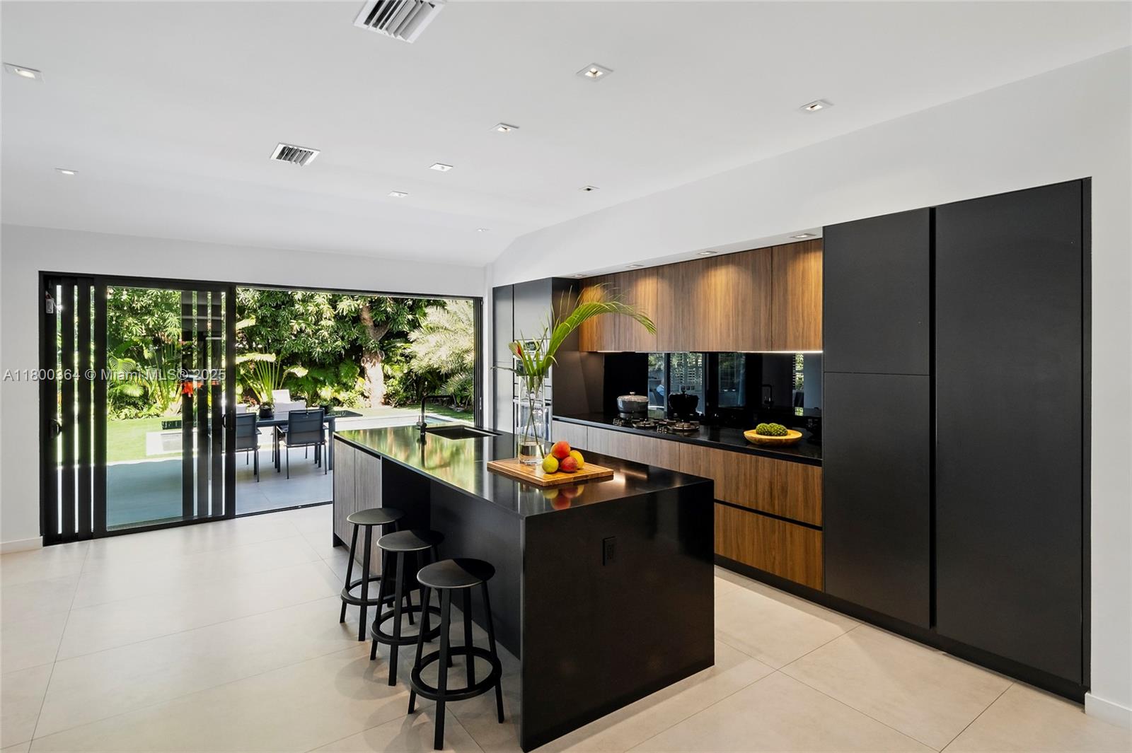 4275 Prairie Avenue Miami Beach, FL 33140 - Photo 13 of 61 a kitchen with stainless steel appliances kitchen island granite countertop a refrigerator and a stove top oven