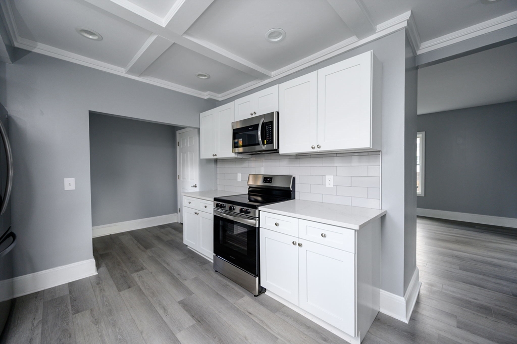 485 Temple Street Whitman, MA 02382 - Photo 7 of 34 a kitchen with granite countertop a stove top oven a sink dishwasher and a refrigerator with wooden floor