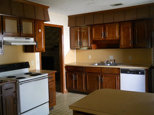 a kitchen with stainless steel appliances granite countertop a refrigerator stove and sink