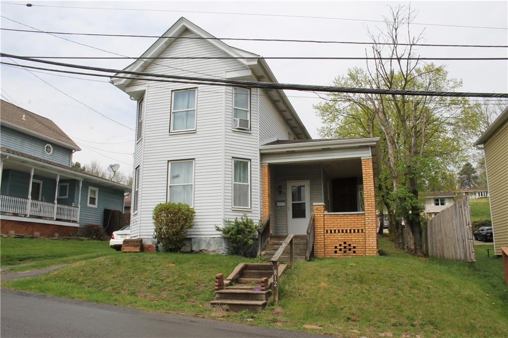 a view of a house with a yard and sitting area