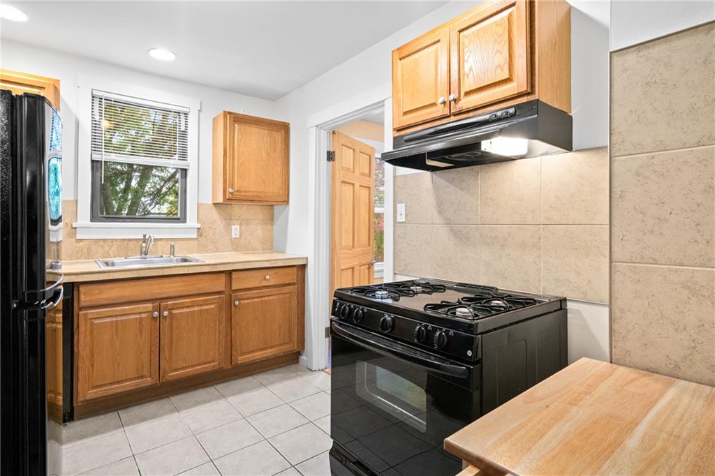 3612 Main Street Homestead, PA 15120 - Photo 12 of 30 a kitchen with granite countertop a stove sink and cabinets