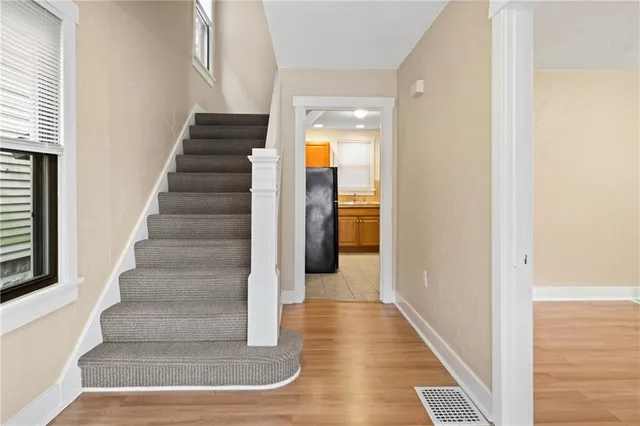 a view of a hallway with wooden floor and entryway