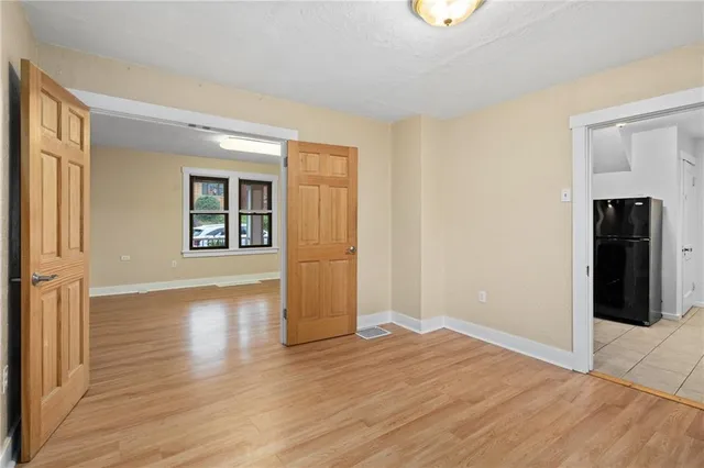 a view of an empty room with window and wooden floor