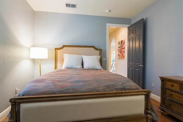 a bedroom with a bed and lamp on table