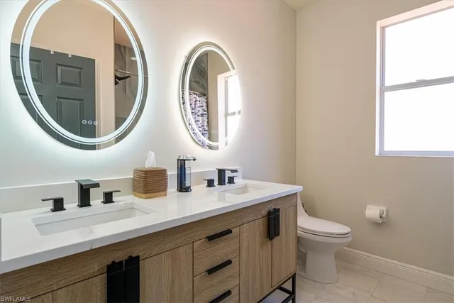 a bathroom with a sink a toilet and a mirror