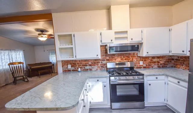 a kitchen with stainless steel appliances granite countertop a stove a sink and a refrigerator